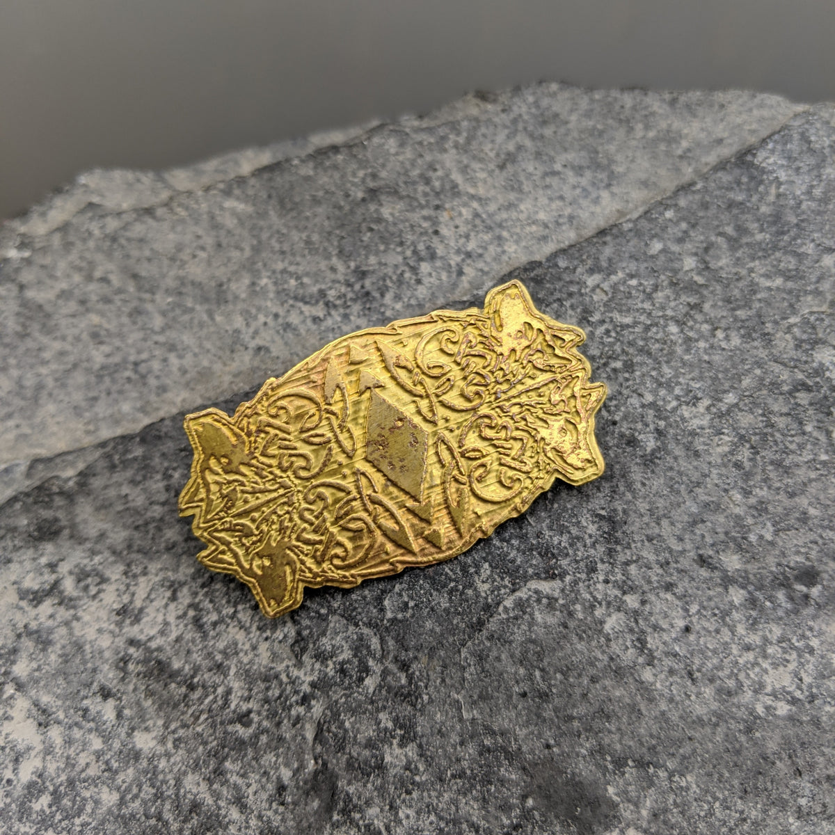 Brass brooch with four wolf design