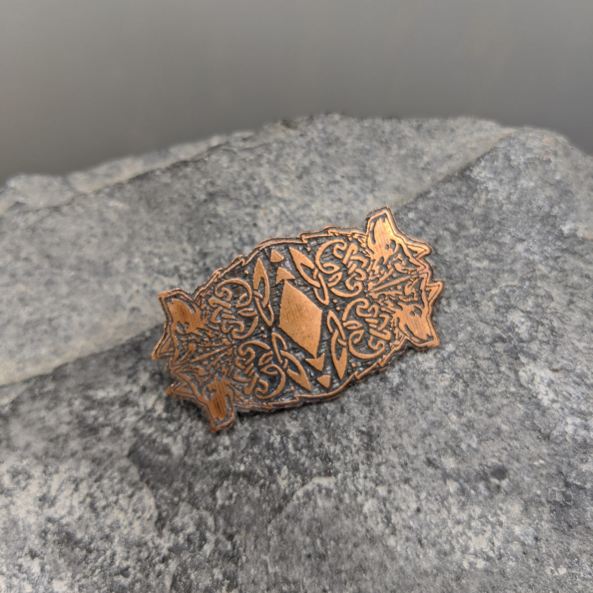 copper brooch with four wolf design