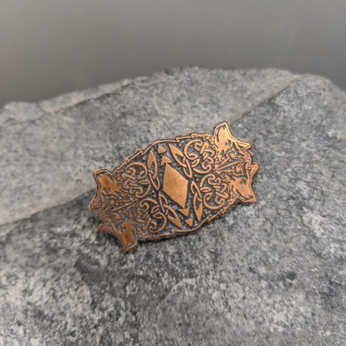 copper brooch with four wolf design 